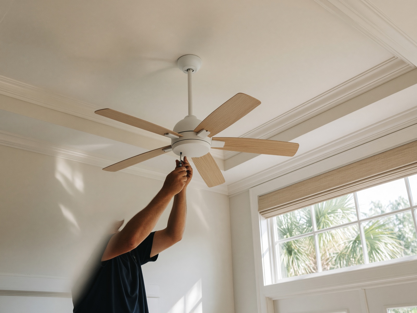 A newly hung ceiling fan with wood blades